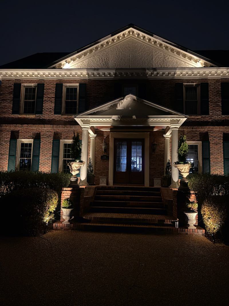 Brick georgian portico, steps and urns lit